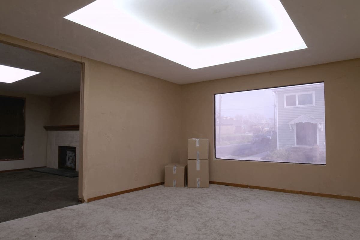 Living room of an older house with belongings partly packed into moving boxes