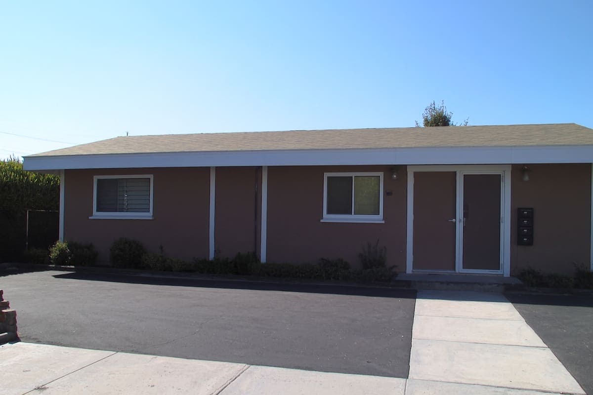 Small two-unit rental building with a shared driveway and a row of mailboxes